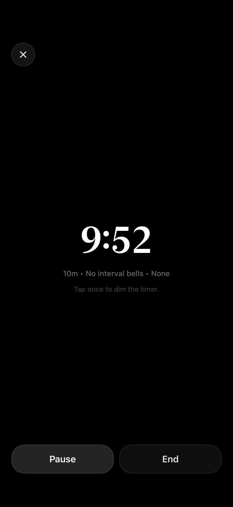 Meditation session with a minimal timer on a dark screen and pause and end controls
